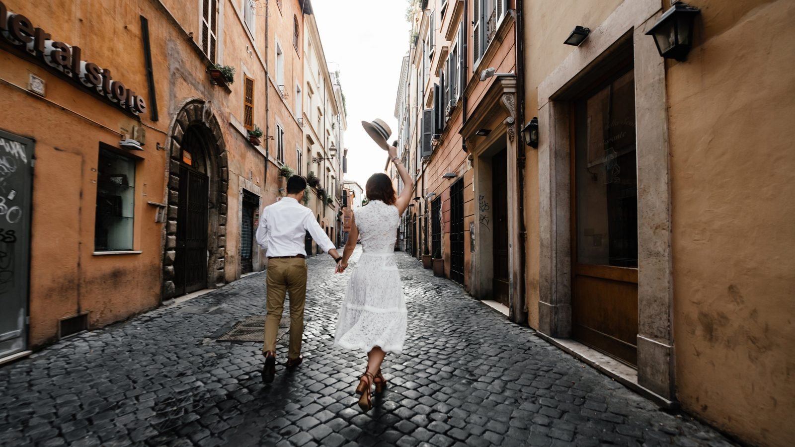 Couple main dans la main dans une ruelle pavée